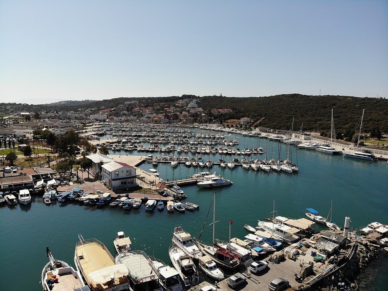 Aerial view of a marina with yachts berthed along the pontoons at golden hour